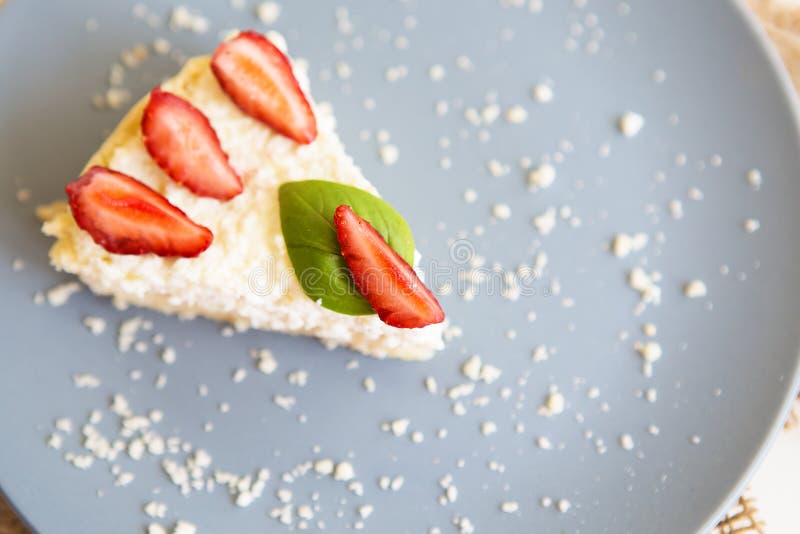 Kawałek wyśmienicie i jaskrawy cheesecake, dekorujący z świeżymi truskawkami i basilów liśćmi zdjęcia stock Kawałek wyśmienicie i jaskrawy cheesecake, dekorujący z świeżymi truskawkami i basilów liśćmi zdjęcia stock