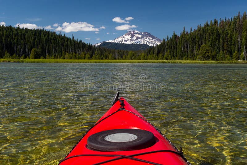 Kayak fahrender schöner See im Sommer in Richtung zur Bergspitze