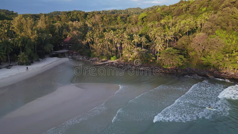 Kayak rides through waves on beach in evening. Marvelous aerial top view drone