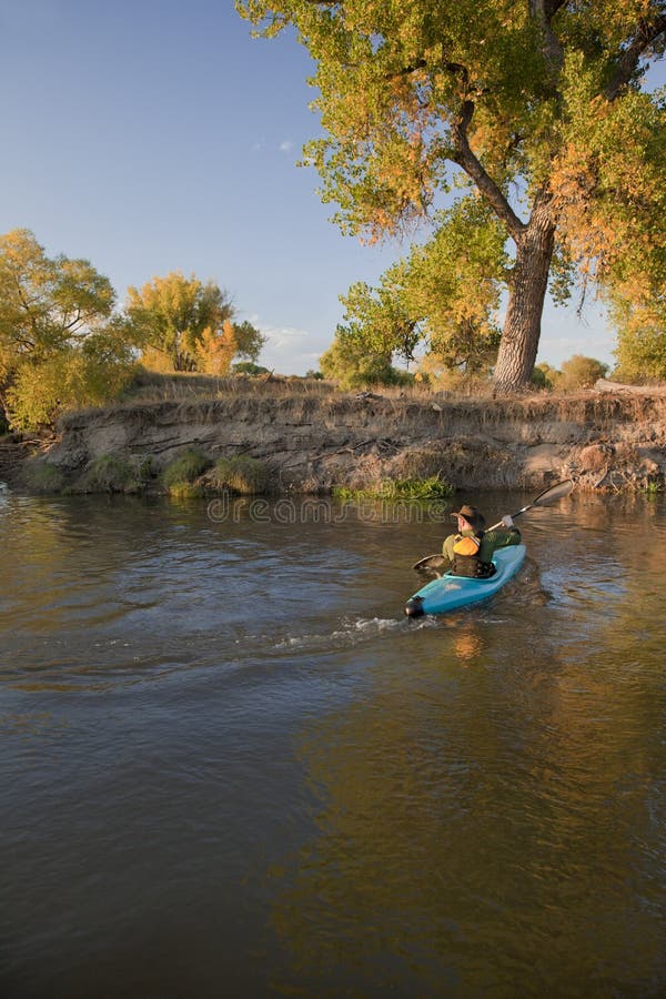 Kayaker paddling across a river