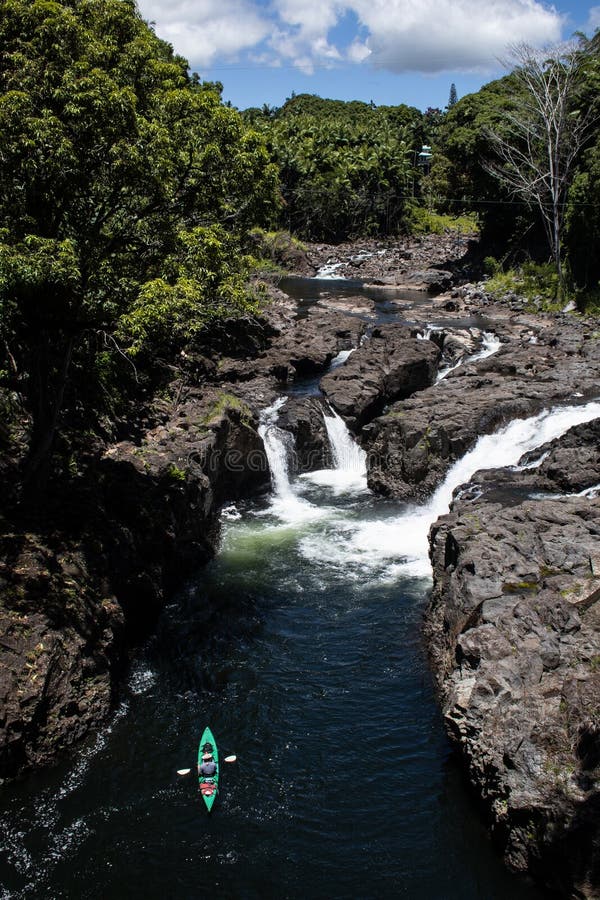Kayaker que rema rio acima no caiaque verde no rio foto de stock Kayaker que rema rio acima no caiaque verde no rio foto de stock
