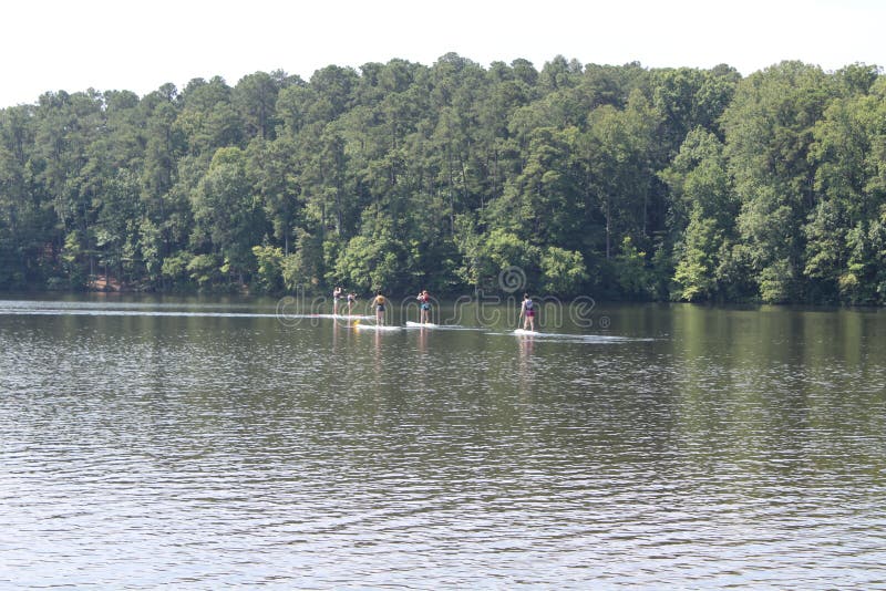 Kayakers enjoy being in the lake. Raleigh,NC/US June 29, 2019 People enjoying themselves kayaking on a sunny day in Lake Johnson with trees in the background royalty free stock photos Kayakers enjoy being in the lake. Raleigh,NC/US June 29, 2019 People enjoying themselves kayaking on a sunny day in Lake Johnson with trees in the background royalty free stock photos