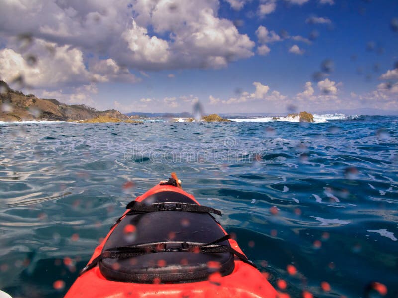 Kayak Approaching Sea Cliffs in Byron Bay Australia. Kayak Approaching Sea Cliffs in Byron Bay Australia