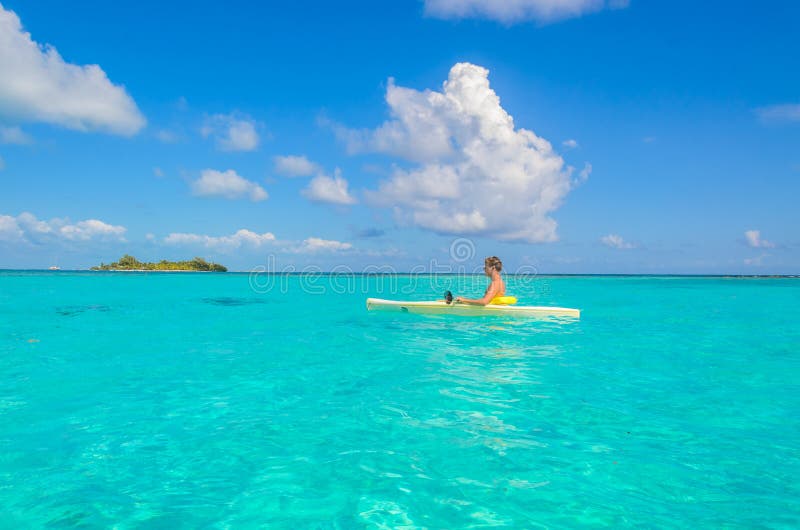 Kayaking en el para?so tropical - canoa que flota en el agua transparente de la turquesa, mar del Caribe, Belice, islas de Cayes foto de archivo Kayaking en el para?so tropical - canoa que flota en el agua transparente de la turquesa, mar del Caribe, Belice, islas de Cayes foto de archivo