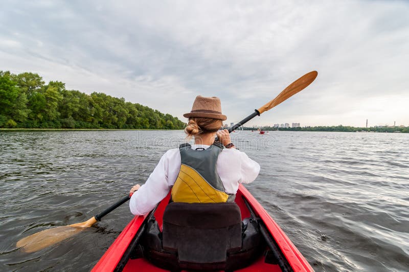 Kayakingsreis Jonge dame die de rode kajak paddelen Achter mening Vakantie en de zomeravontuur stock afbeelding Kayakingsreis Jonge dame die de rode kajak paddelen Achter mening Vakantie en de zomeravontuur stock afbeelding