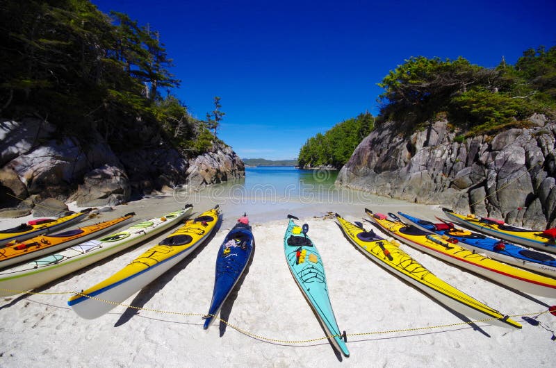 Kayaks de mer sur la plage dans la crique arénacée photos libres de droits Kayaks de mer sur la plage dans la crique arénacée photos libres de droits