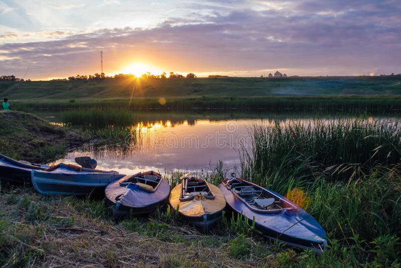 Kayaks sur la berge Beau coucher du soleil sur la rivière photo libre de droits Kayaks sur la berge Beau coucher du soleil sur la rivière photo libre de droits