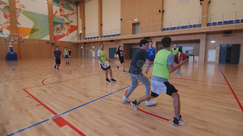 Teenager throws ball and shoots goal to opponents in gym