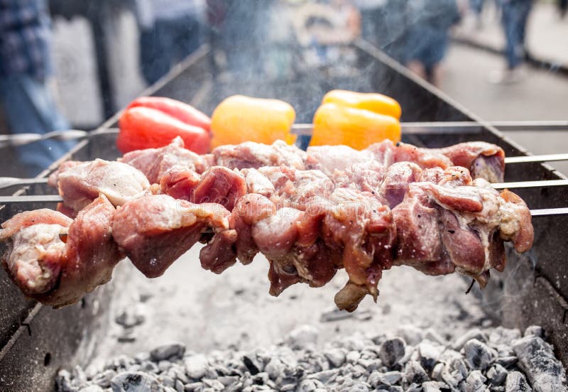 Kebab asado a la parrilla que cocina en el pincho del metal Carne asada cocinada en la barbacoa con el paprika rojo y amarillo fotografía de archivo libre de regalías Kebab asado a la parrilla que cocina en el pincho del metal Carne asada cocinada en la barbacoa con el paprika rojo y amarillo fotografía de archivo libre de regalías