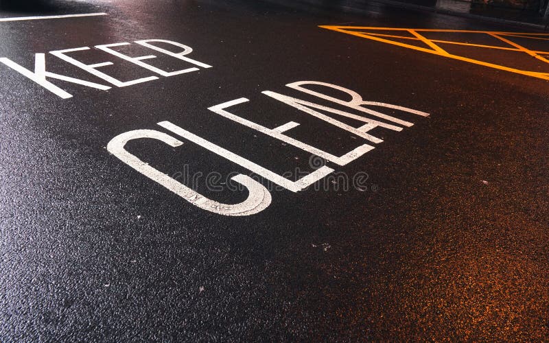 Keep Clear written on the wet asphalt road