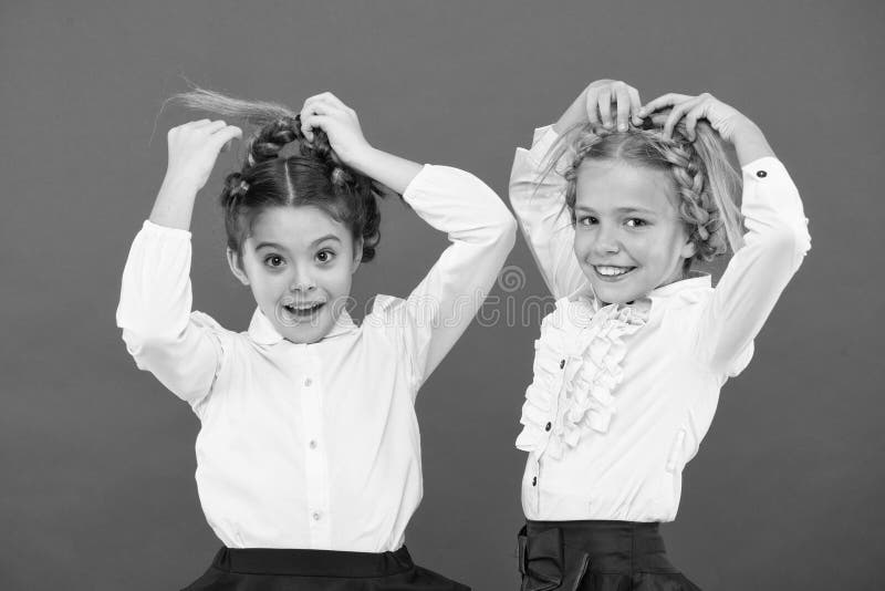 Keep hair braided for tidy look. Kids pupils play with long braided hair. Hairdresser salon. Hairstyles which suits to. Formal school style. Appropriate stock photography Keep hair braided for tidy look. Kids pupils play with long braided hair. Hairdresser salon. Hairstyles which suits to. Formal school style. Appropriate stock photography
