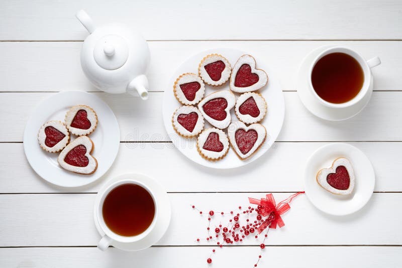 Keksherz formte Plätzchen für Valentinsgrußtag mit Teekanne und zwei Tassen Tee auf weißem hölzernem Hintergrund gebacken lizenzfreies stockbild Keksherz formte Plätzchen für Valentinsgrußtag mit Teekanne und zwei Tassen Tee auf weißem hölzernem Hintergrund gebacken lizenzfreies stockbild