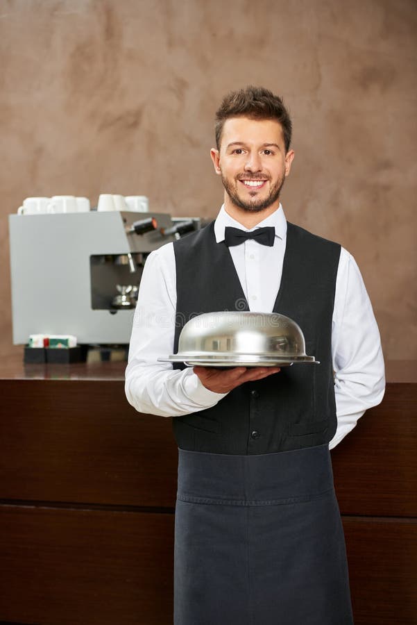 Waiter in uniform with food cloche in a hotel restaurant. Waiter in uniform with food cloche in a hotel restaurant