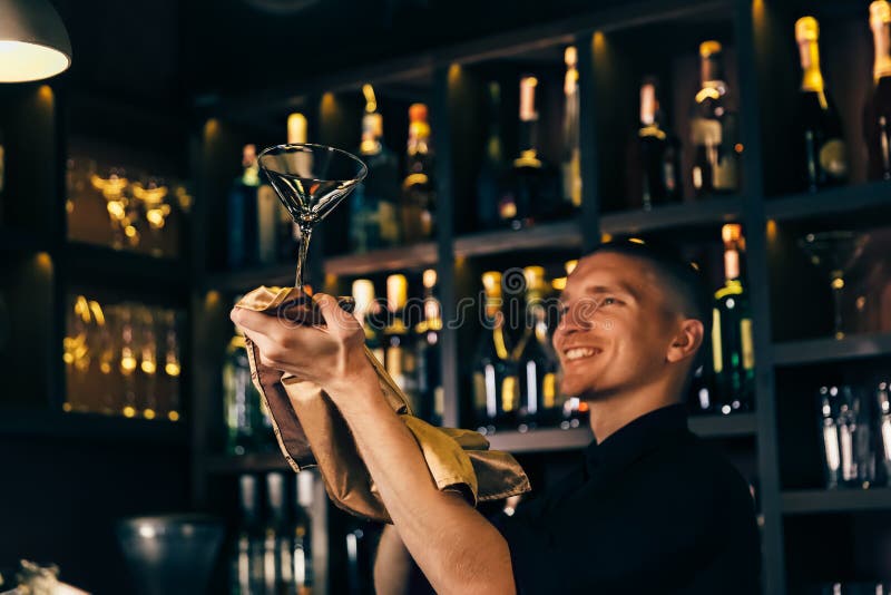 Kellner passt ein Kristallglas auf Der Barmixer, der das Glas auf der Stange säubert stockfoto Kellner passt ein Kristallglas auf Der Barmixer, der das Glas auf der Stange säubert stockfoto
