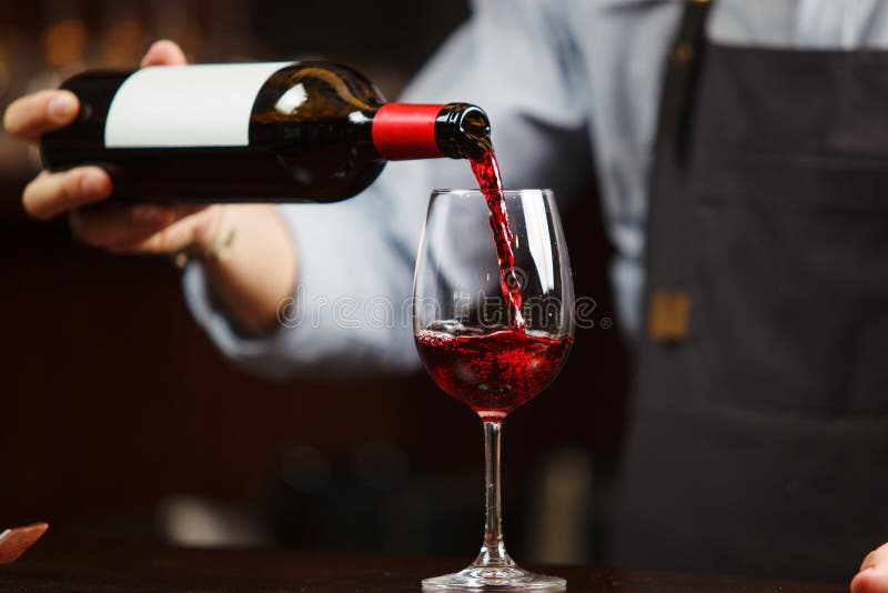 Kelner die rode wijn gieten in wijnglas Sommelier giet alcoholische drank