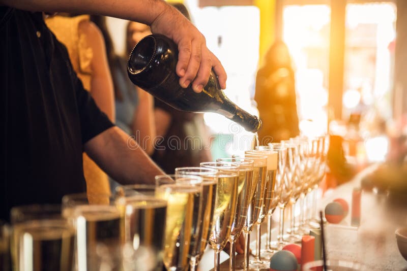 Waiter pouring champagne into glasses on party event in the bar. Waiter pouring champagne into glasses on party event in the bar