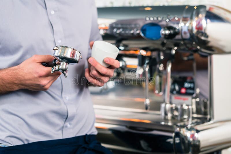 Kelnera narządzania kawa espresso przy automatyczną kawową maszyną obraz royalty free