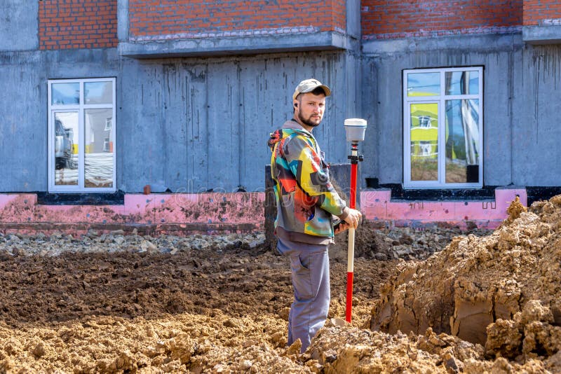 May 14, 2021, Kemerovo, Russia. A surveyor makes measurements using GPS equipment and strictly looks into the camera, selective focus. May 14, 2021, Kemerovo, Russia. A surveyor makes measurements using GPS equipment and strictly looks into the camera, selective focus