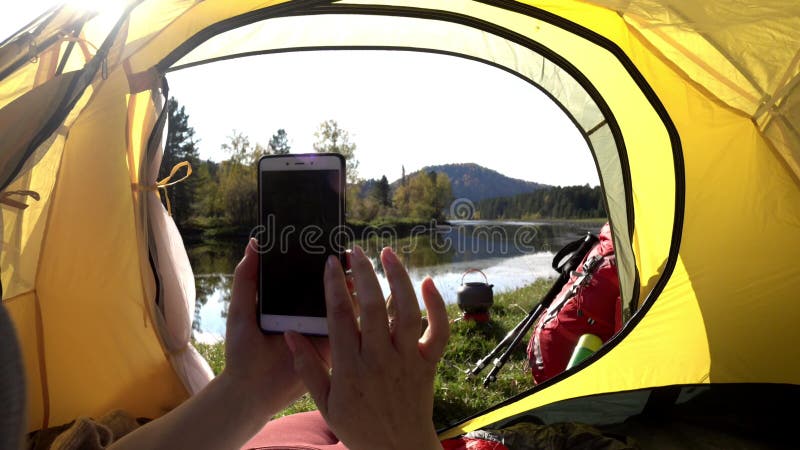 Kempingowa kobieta leżąca w namiocie, w pobliżu nóg dziewczyn, w butach turystycznych relaksujących się na wakacjach.