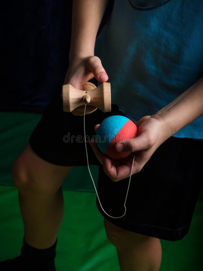 Kendama japonés clásico del juego, manos del muchacho que juegan kendama fotografía de archivo Kendama japonés clásico del juego, manos del muchacho que juegan kendama fotografía de archivo