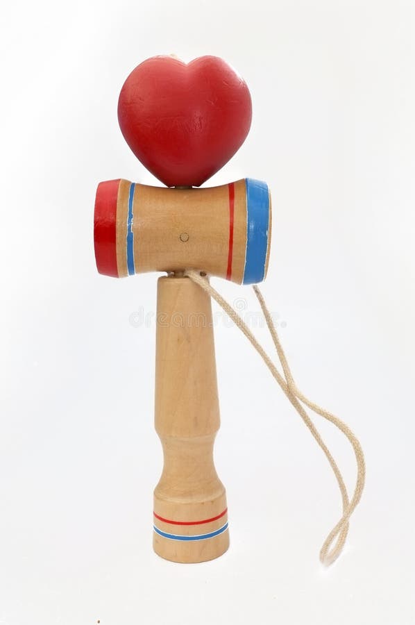 Kendama, традиционная японская игрушка состоя из шпаги и шарика сердца соединенных строкой свернутой в изолированной форме сердца стоковые изображения