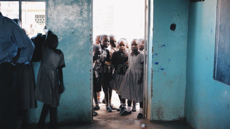 KENIA, KISUMU - 20 DE MAYO DE 2017: El grupo de niños en uniforme entra en la clase y se prepara para la lección en la escuela en foto de archivo KENIA, KISUMU - 20 DE MAYO DE 2017: El grupo de niños en uniforme entra en la clase y se prepara para la lección en la escuela en foto de archivo