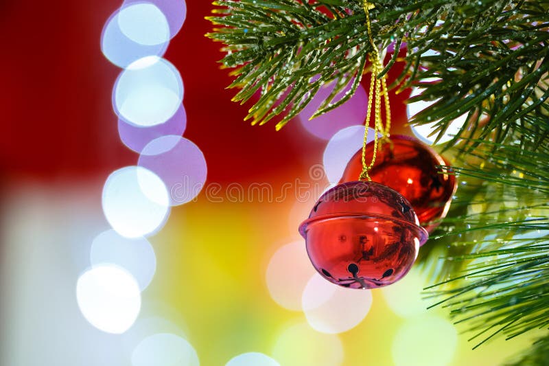 Kenwijsjeklokken op Kerstboom met abstracte lichte achtergrond stock afbeeldingen Kenwijsjeklokken op Kerstboom met abstracte lichte achtergrond stock afbeeldingen