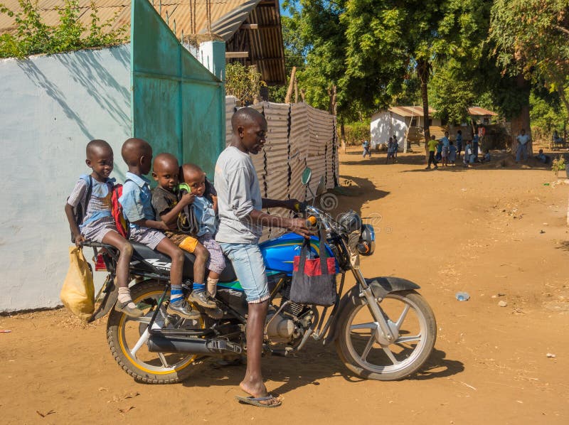 Kenyanmann mit vier Kindern auf Motorrad stockbild Kenyanmann mit vier Kindern auf Motorrad stockbild