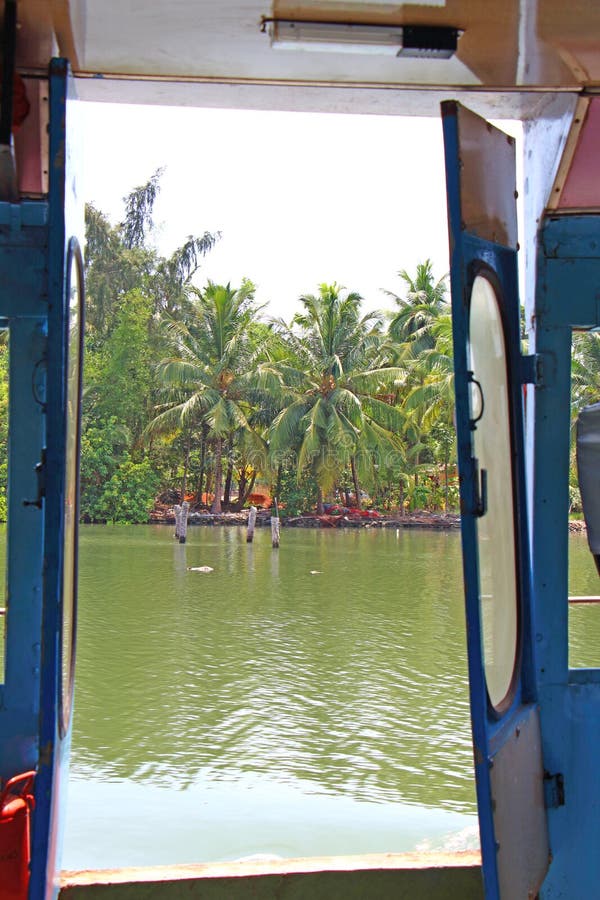 Kerala backwaters from the tourist boat window. Tourist boat window, south india, kerala state, canals, swtd ferry, tropics, palms and water, nature from royalty free stock photos Kerala backwaters from the tourist boat window. Tourist boat window, south india, kerala state, canals, swtd ferry, tropics, palms and water, nature from royalty free stock photos