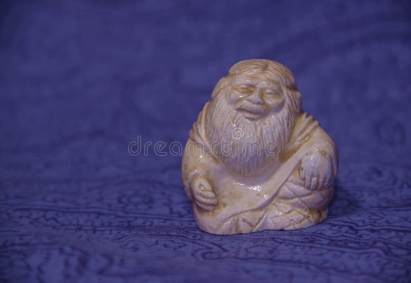 Keramisk kinesisk vis statyett som sitter på en blå bakgrund royaltyfri fotografi Keramisk kinesisk vis statyett som sitter på en blå bakgrund royaltyfri fotografi