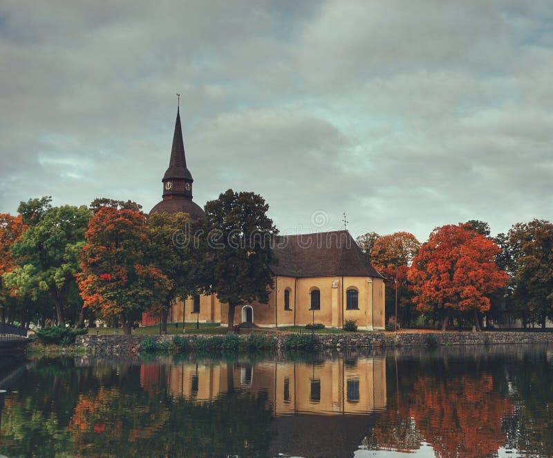 Kerk in een meer in de herfst tegen de hemel stock foto