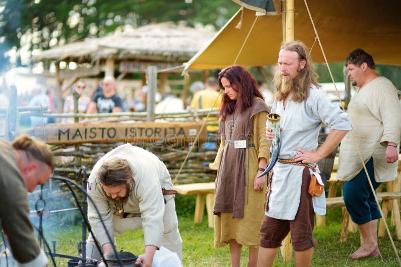 KERNAVE LITAUEN - JULI 6, 2018: Historiska reenactmentaktivister som bär medeltida dräkter under årlig festival av fotografering för bildbyråer KERNAVE LITAUEN - JULI 6, 2018: Historiska reenactmentaktivister som bär medeltida dräkter under årlig festival av fotografering för bildbyråer
