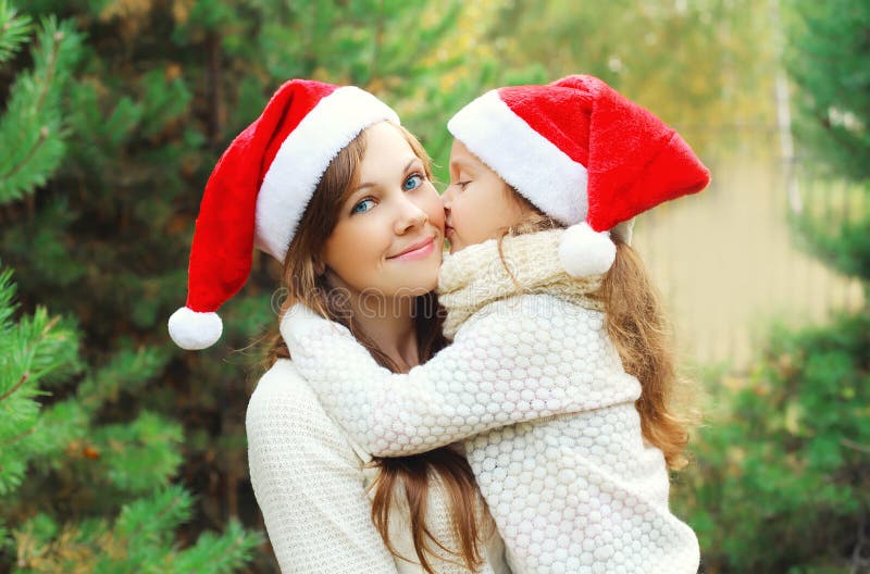 Kerstmis, familieconcept - de kussende moeder van het meisjekind stock afbeelding Kerstmis, familieconcept - de kussende moeder van het meisjekind stock afbeelding