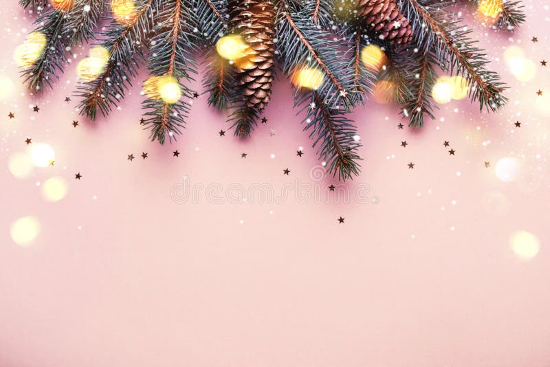 Kerstmis naaldgrens met kegels en bokeh lichten Roze achtergrond