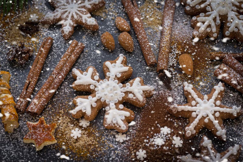 Kerstmis of Nieuwjaarachtergrond van Peperkoekkoekjes, kruiden, noten met suiker en sneeuwvlokken Hoogste mening stock afbeelding Kerstmis of Nieuwjaarachtergrond van Peperkoekkoekjes, kruiden, noten met suiker en sneeuwvlokken Hoogste mening stock afbeelding