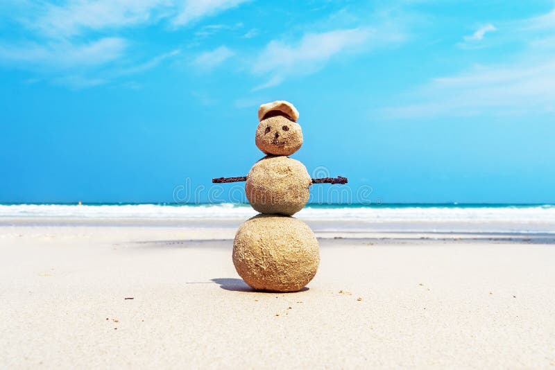 Kerstmis positief Sandy Snowman in rode Santa Claus-hoed bij oceaanzonsondergangstrand royalty-vrije stock fotografie Kerstmis positief Sandy Snowman in rode Santa Claus-hoed bij oceaanzonsondergangstrand royalty-vrije stock fotografie
