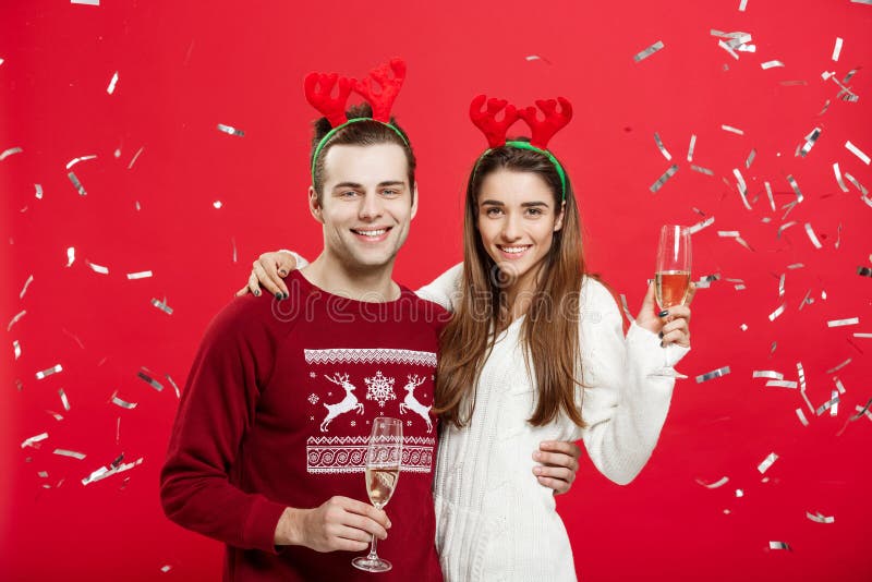 Kerstmisconcept - Gelukkige Kaukasische man en vrouw die in rendierhoeden Kerstmis het roosteren met champagnefluiten vieren royalty-vrije stock fotografie Kerstmisconcept - Gelukkige Kaukasische man en vrouw die in rendierhoeden Kerstmis het roosteren met champagnefluiten vieren royalty-vrije stock fotografie