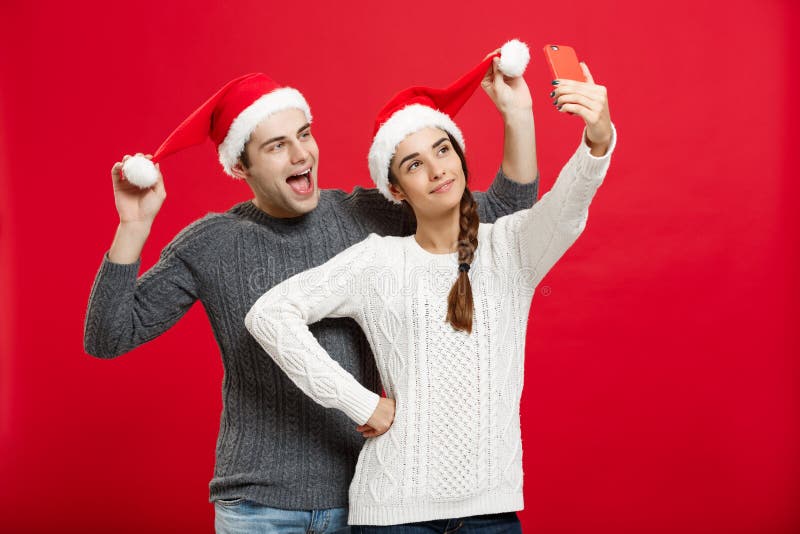 Kerstmisconcept - Jong aantrekkelijk paar die een selfie nemen door mobiele telefoon in Kerstmisdag te vieren royalty-vrije stock afbeeldingen Kerstmisconcept - Jong aantrekkelijk paar die een selfie nemen door mobiele telefoon in Kerstmisdag te vieren royalty-vrije stock afbeeldingen