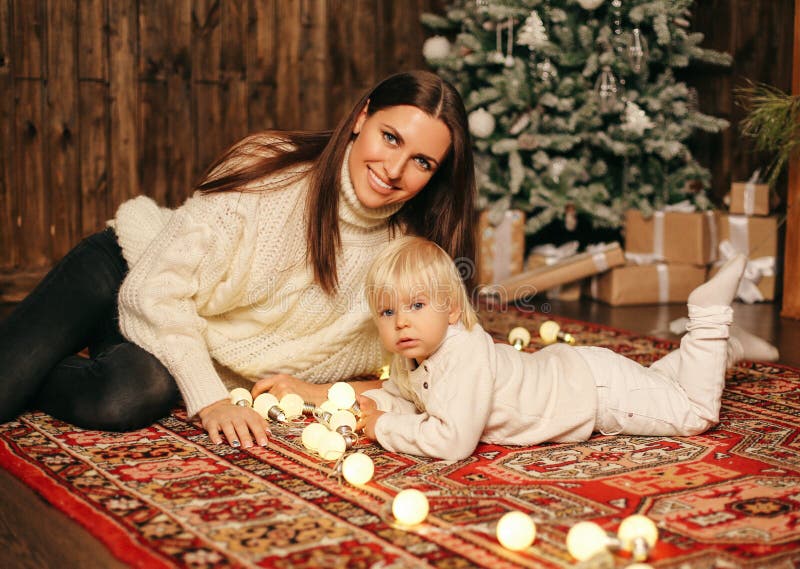 Kerstmisfoto van kleine leuke jongen en zijn mooie moederplayi stock afbeeldingen Kerstmisfoto van kleine leuke jongen en zijn mooie moederplayi stock afbeeldingen