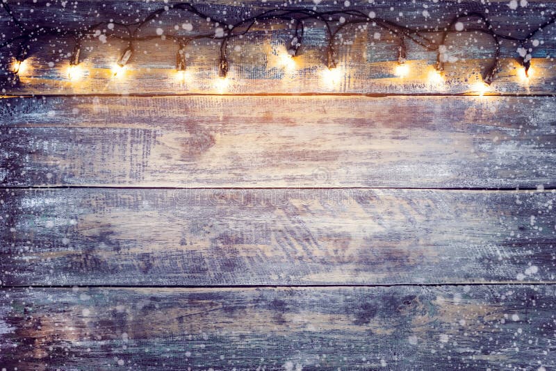 Kerstmisgloeilamp met sneeuw op houten lijst stock foto Kerstmisgloeilamp met sneeuw op houten lijst stock foto