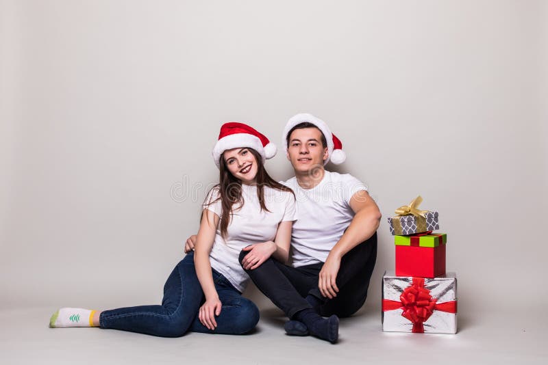 Kerstmispaar met giften het zitten stock fotografie Kerstmispaar met giften het zitten stock fotografie