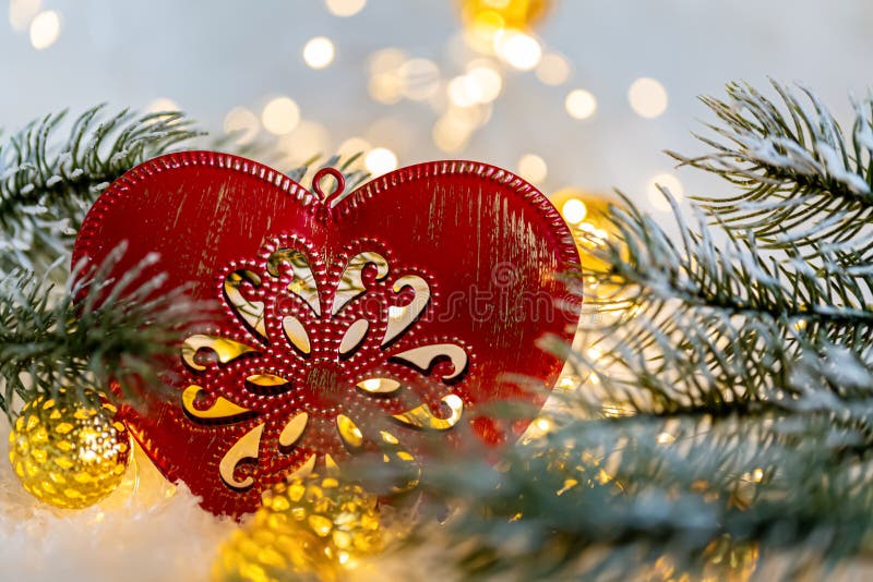 Christmas toy red heart with ornament on the snow. Pine branches on ice crystals. Background and bokeh. Shallow depth of field. Toned image. Copy space. Macro. Happy Merry Christmas and New year. Christmas toy red heart with ornament on the snow. Pine branches on ice crystals. Background and bokeh. Shallow depth of field. Toned image. Copy space. Macro. Happy Merry Christmas and New year.