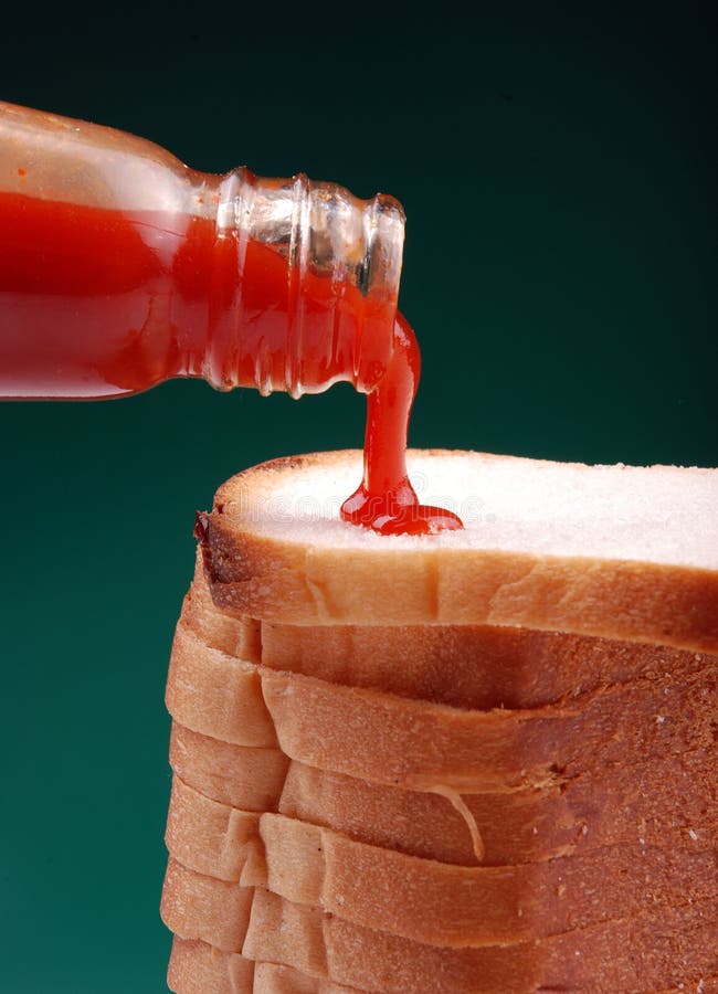 Pouring ketchup on stack of milky breads. Pouring ketchup on stack of milky breads