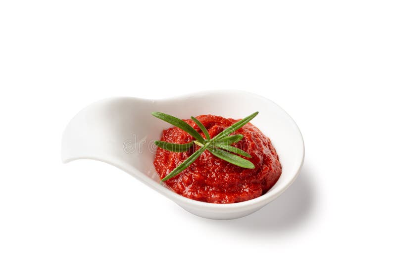 Ketchup splash or tomato sauce blob isolated on white background with clipping path. Catsup paste dollop or pomidor splash drop with fresh greens