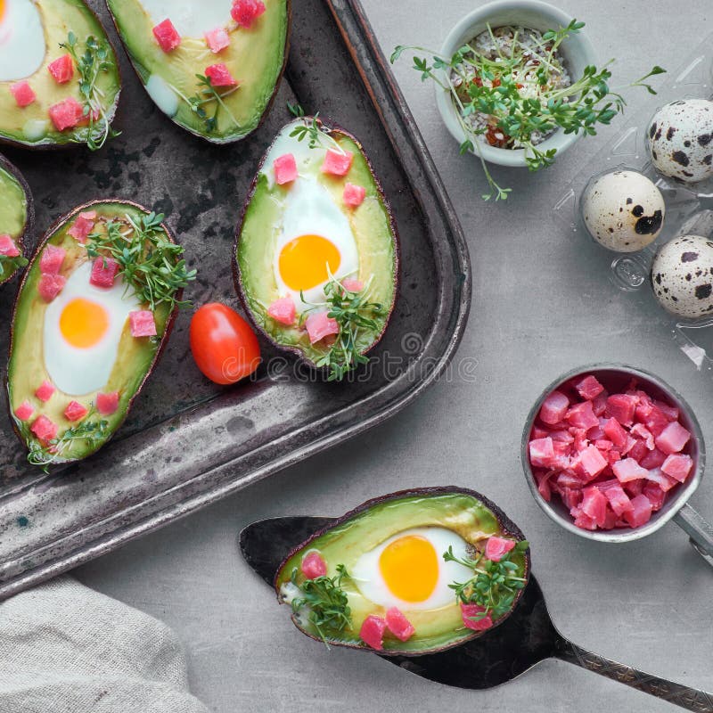Keto diet dish: Avocado boats with ham cubes, quail eggs and cherry tomatoes royalty free stock photos Keto diet dish: Avocado boats with ham cubes, quail eggs and cherry tomatoes royalty free stock photos