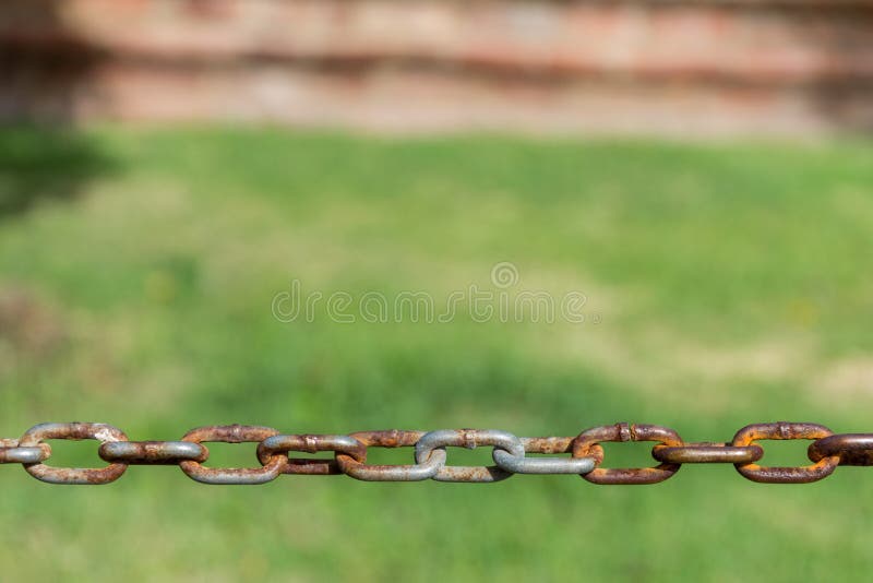 Ketting met roest op groene weideachtergrond stock foto's Ketting met roest op groene weideachtergrond stock foto's