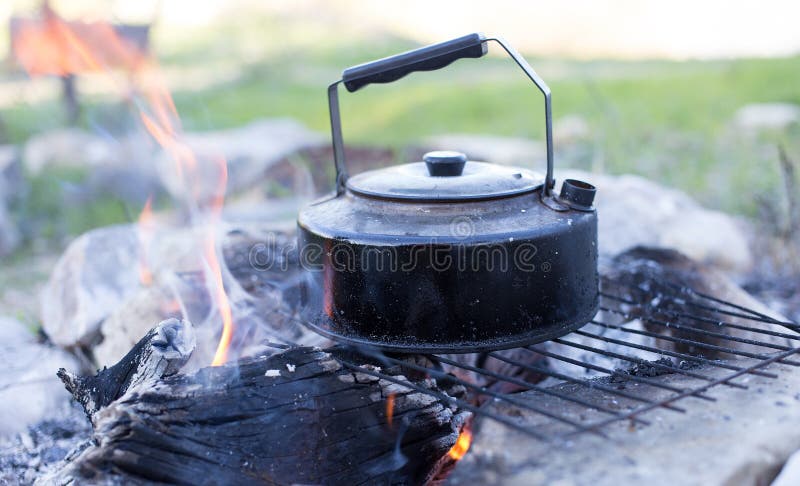 Low angle shot of a tea kettle over an open flame, capturing the essence of  traditional tea brewing and the warmth of the fire. 28781591 Stock Photo at  Vecteezy