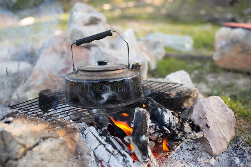 Low angle shot of a tea kettle over an open flame, capturing the essence of  traditional tea brewing and the warmth of the fire. 28781591 Stock Photo at  Vecteezy