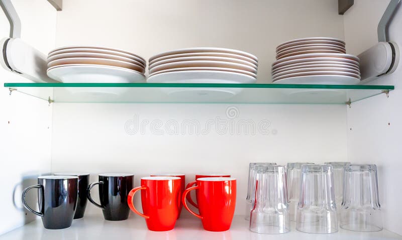 Keukenkast met disheslikeplaten, koppen en glazen stock afbeeldingen Keukenkast met disheslikeplaten, koppen en glazen stock afbeeldingen