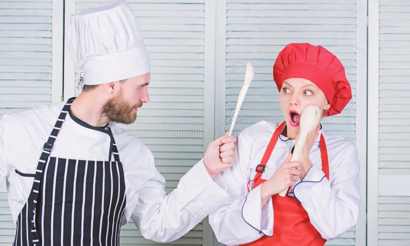 Keukenregels Culinair slagconcept De culinaire vrouw en de gebaarde man tonen concurrenten Who betere kok uiteindelijk stock foto's Keukenregels Culinair slagconcept De culinaire vrouw en de gebaarde man tonen concurrenten Who betere kok uiteindelijk stock foto's